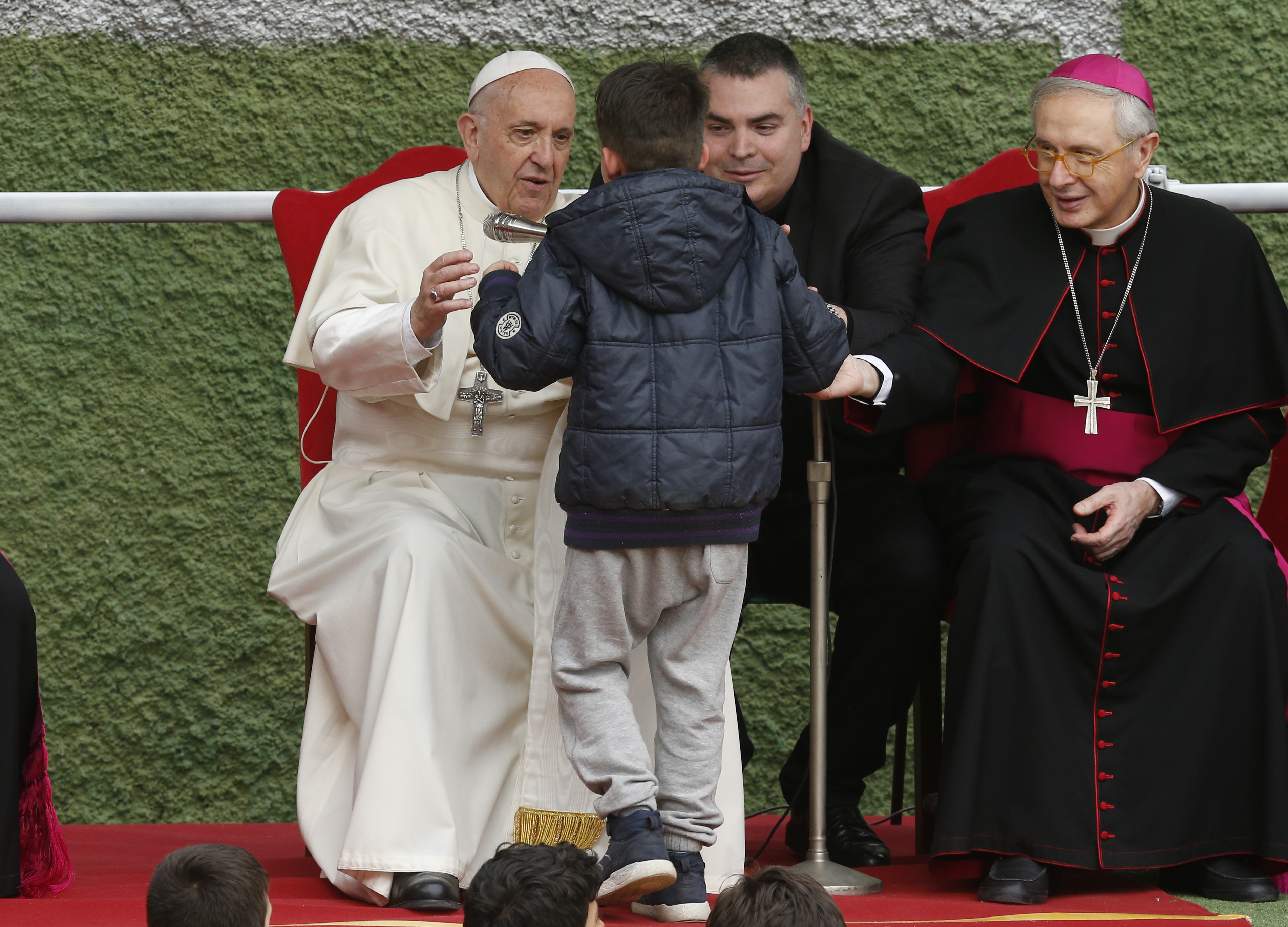 Pope Francis asks Emanuele to come on stage and whisper his question because he had difficulty saying it aloud.