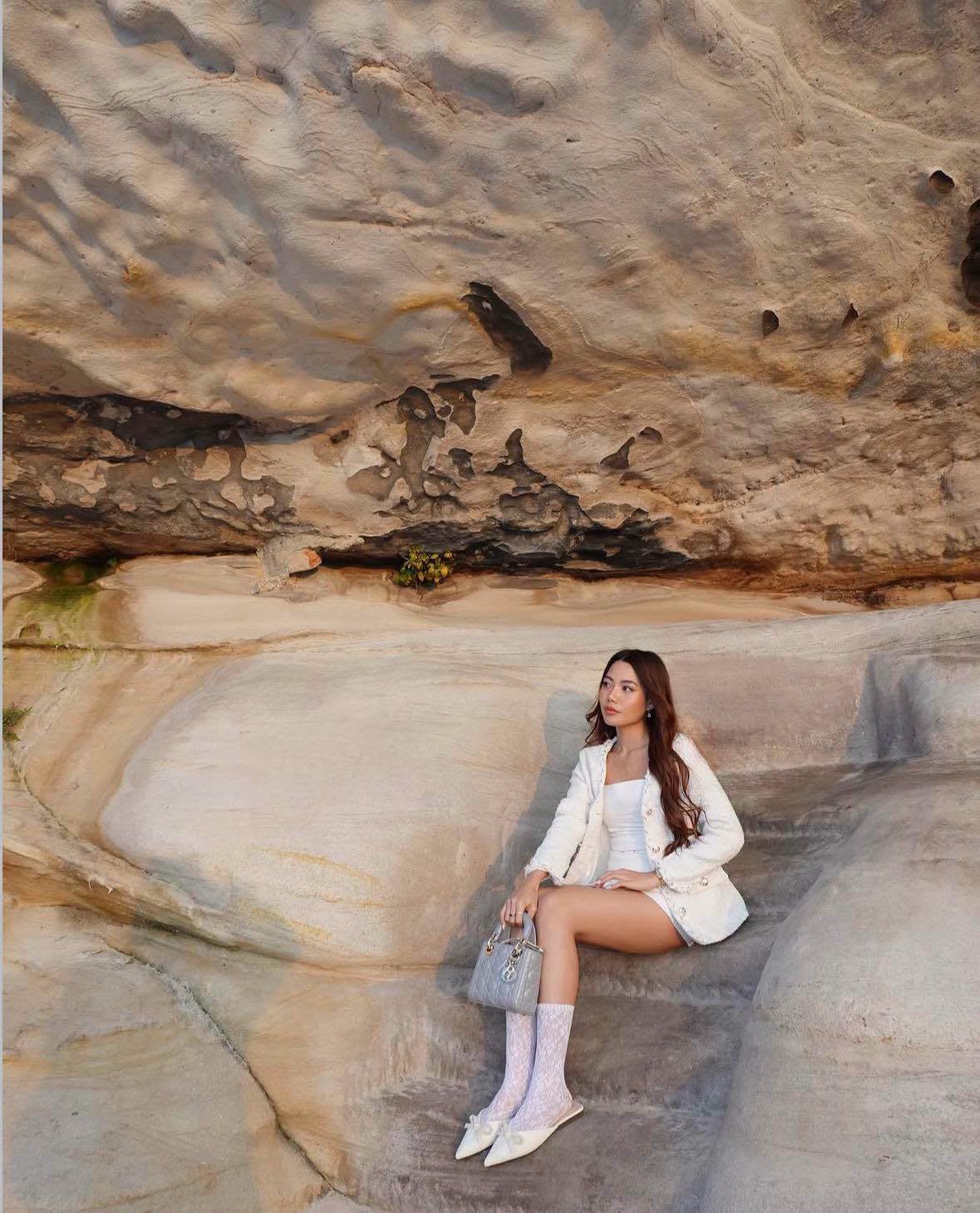 Zofia Canlas poses for a travel OOTD in an all-white ensemble, accessorized with a Lady Dior handbag. Photos of her lifestyle and international travels have drawn attention following her appointment as PCUP commissioner.