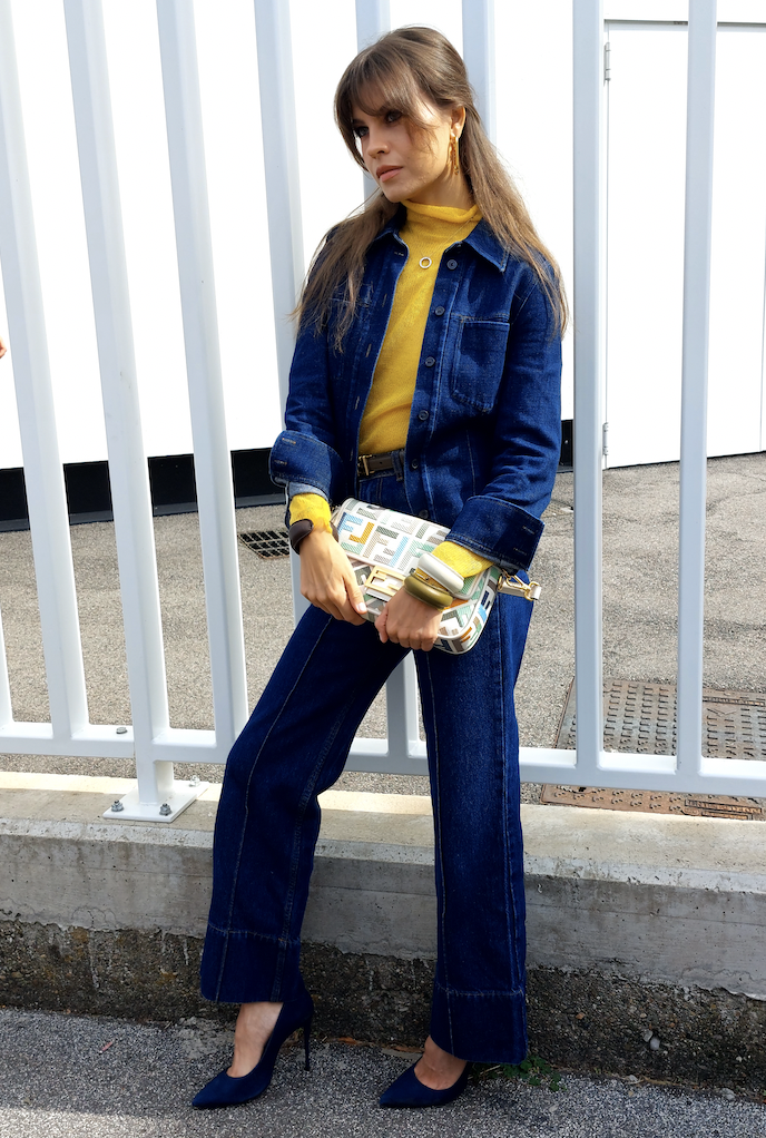 Woman in yellow turtleneck and denim jacket and pants attending Paris Fashion Week