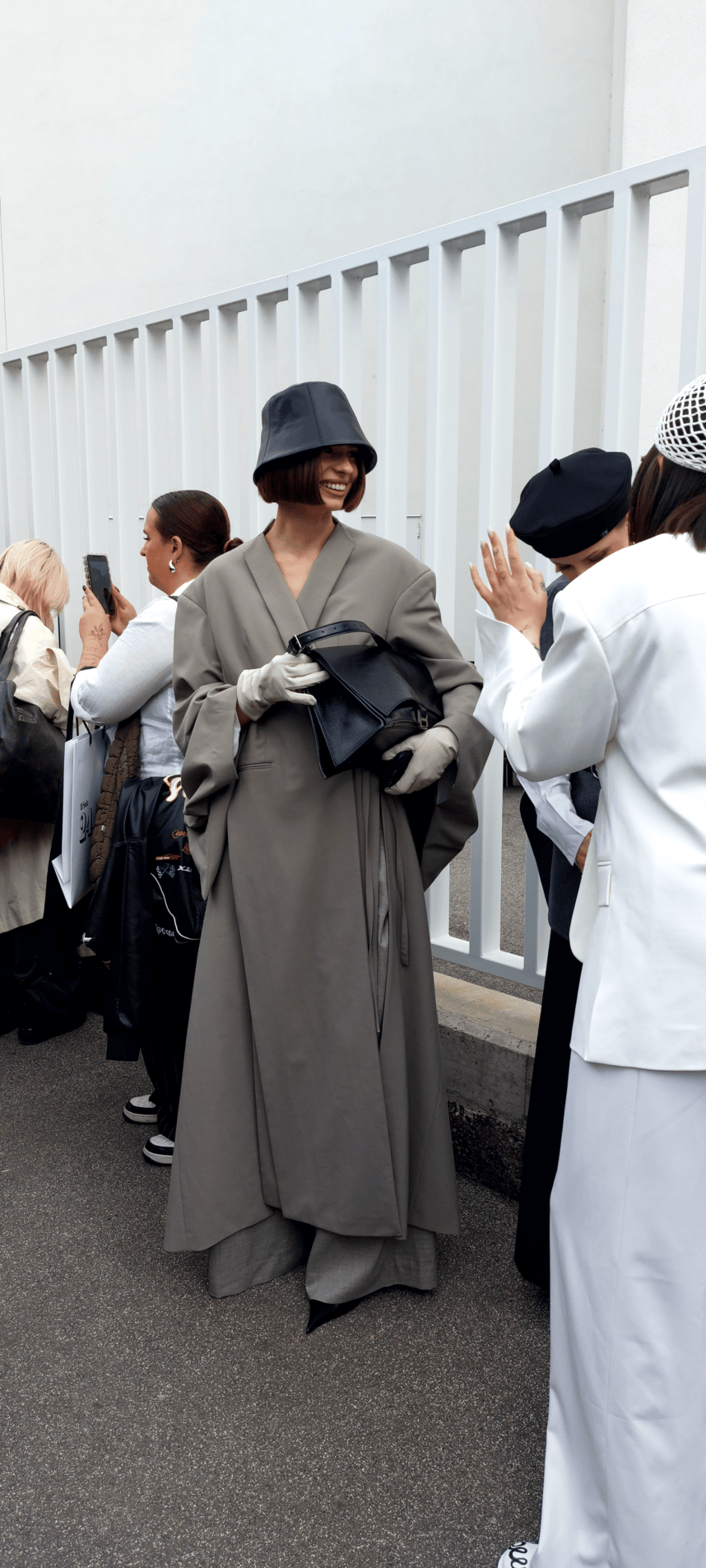 Woman in floor length coat and bucket hat attending Paris Fashion Week